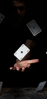 Floating playing cards above a hand in dim lighting.