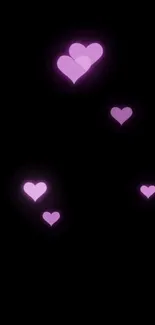 Mobile wallpaper with glowing purple hearts on a black background.