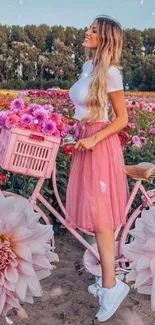 Woman in pink skirt with bike in flower field.