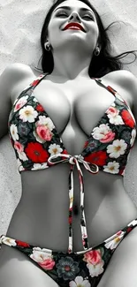 Woman in floral bikini lying on sandy beach.