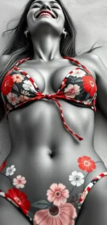 Woman in floral bikini lying on beach sand, smiling.