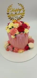 Elegant birthday cake with floral decorations and macarons.