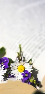 Mobile wallpaper with daisies and violets on an open book.