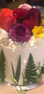 Cake adorned with vibrant flowers and sparkling decorations.