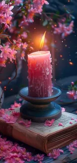 Enchanting pink candle with cherry blossoms on an open book.