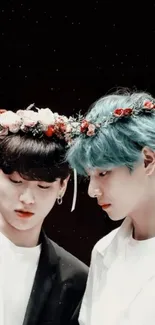 Two friends with floral crowns against a dark background.