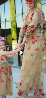 Mother and daughter in matching floral dresses, smiling outdoors.