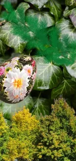 A decorative floral egg amongst lush green leaves.