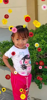 Child surrounded by vibrant flowers against a green backdrop.