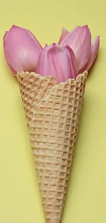 Ice cream cone filled with pink flowers on yellow background.