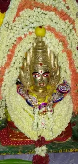 Hindu deity adorned with colorful flower garlands.