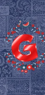 Red letter G with floral design on blue.