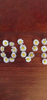 Love spelled with daisies on wood background, mobile wallpaper.