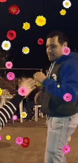 Man dancing at night surrounded by colorful flowers.