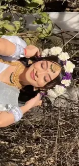 Woman in traditional outfit with flower crown against natural background.