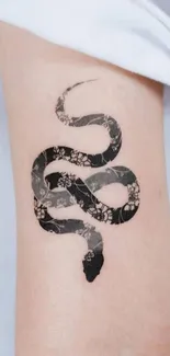 Floral pattern snake tattoo on arm.