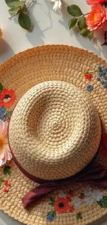 Floral straw hat with vibrant flowers on a light surface.