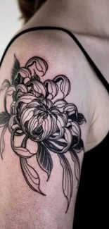 Intricate floral tattoo in black ink on arm.