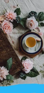 Floral arrangement with tea cup and vintage book on beige fabric.