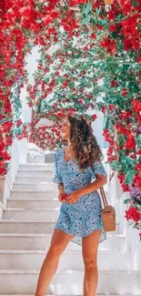 Woman on white stairs surrounded by red flowers.