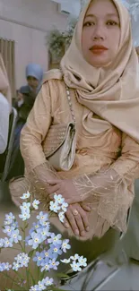 Elegant woman in beige hijab with floral accents.