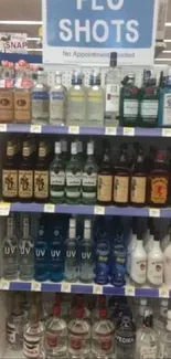 Funny store display with flu shots sign and liquor bottles.