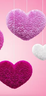 Fluffy pink hearts hanging on a soft pink background