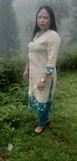 Woman in traditional attire in a foggy garden.