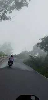 Motorcycle journey on a misty mountain road.