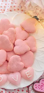 Pink heart cookies and love décor on a white plate create a romantic vibe.