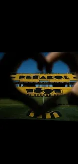 Heart-shaped view framing a football stadium, vibrant and dynamic.