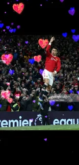 Football player celebrates a goal in a Premier League match amid cheering crowd.