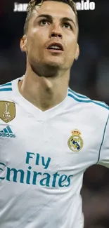 Football player in white Real Madrid jersey on field.