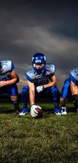 Football team in blue uniforms on a grass field at night.