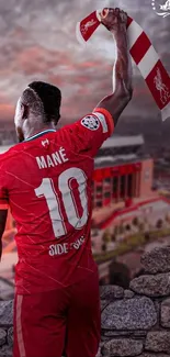 Football player celebrates with scarf overlooking stadium.