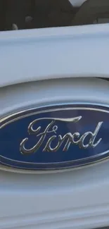 Ford logo in chrome and blue on a mobile wallpaper.