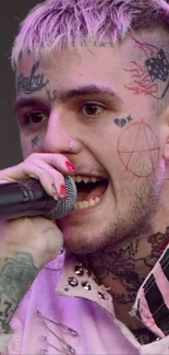 Tattooed singer performing on stage with microphone and purple hair.