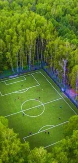 Aerial view of soccer field in lush forest setting, vibrant green mobile wallpaper.