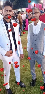 Two men in formal suits at a vibrant night event.