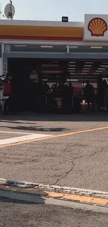 Formula 1 car in garage during pit stop with crew around.