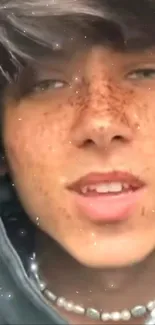 Freckled face close-up portrait with hoodie in natural light.