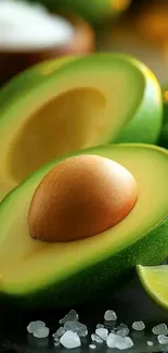Close-up of halved avocado with lime and salt.