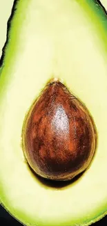 Vibrant green avocado wallpaper with seed on pale background.