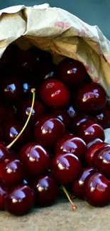 A pile of ripe cherries spilling from a paper bag on the ground.