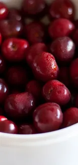 Vibrant cherries in a white bowl, perfect for a fresh phone wallpaper.