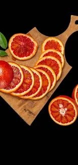 Wooden board with sliced citrus fruits on black background.