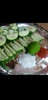 Freshly cut green guavas with lime, salt, and chili on a platter.