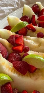 Fresh fruit slices with melons, strawberries, and limes.