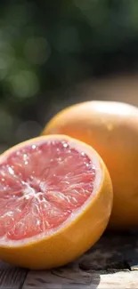 Sliced grapefruit on a rustic wooden table with blurred background.