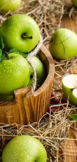 Fresh green apples in a rustic basket on hay with a wooden surface.